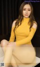 a woman in a yellow top sitting on a table