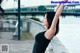 A woman in a black dress leaning against a railing.