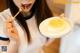 A woman holding a bowl of food with a spoon in it.