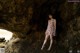 A woman standing in the middle of a cave.